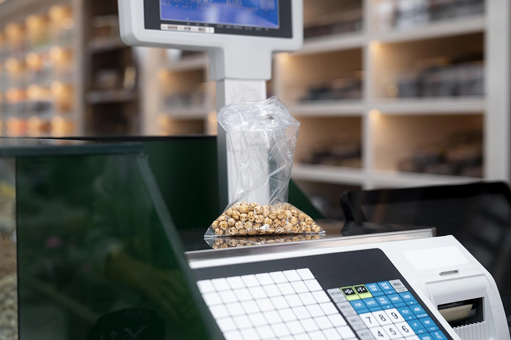Une balance poids prix aidant la manipulation des logiciel de magasin, un produits est pesé dessus
